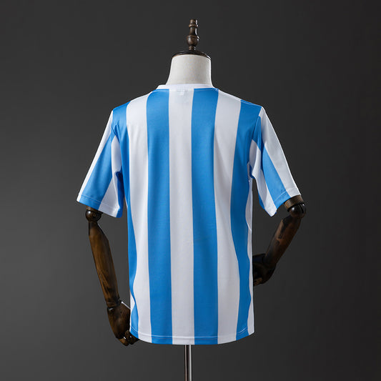 Camiseta retro Argentina 1986 primera equipación detalle escudo Maradona – Cortita y al Pie
