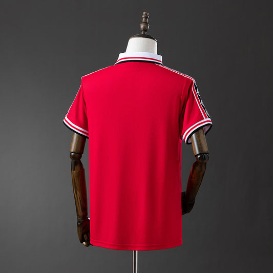 Camiseta retro Manchester United 1998/99 primera equipación detalle escudo Treble – Cortita y al Pie