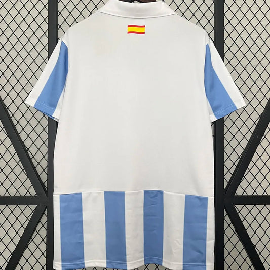 Camiseta retro Málaga CF 2012/13 primera equipación detalle escudo UCL – Cortita y al Pie