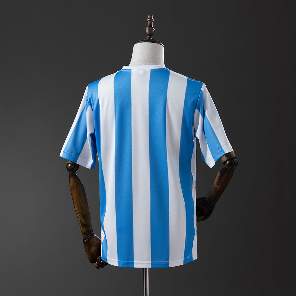 Camiseta retro Argentina 1986 primera equipación detalle escudo Maradona – Cortita y al Pie