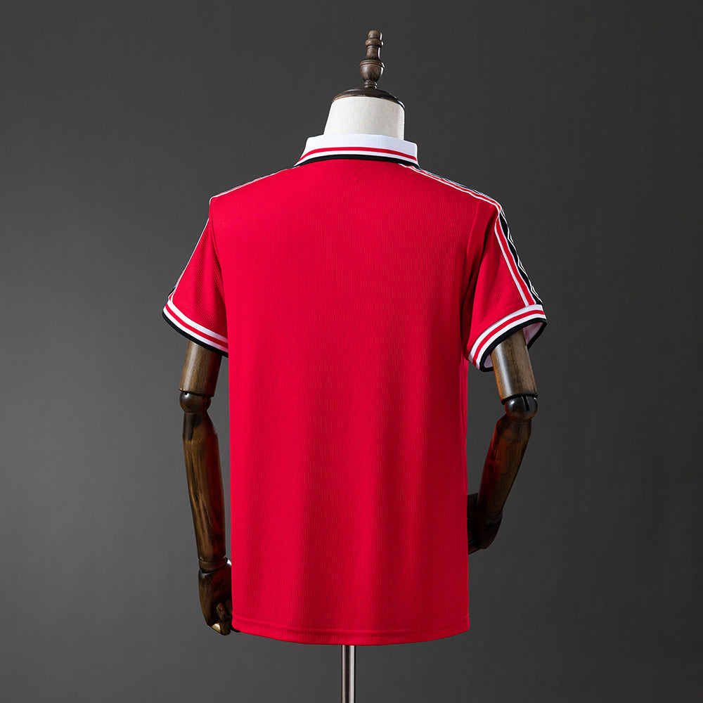 Camiseta retro Manchester United 1998/99 primera equipación detalle escudo Treble – Cortita y al Pie