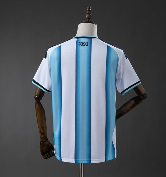 Camiseta Argentina Mundial 2026 primera equipación versión fan detalle escudo AFA – Cortita y al Pie