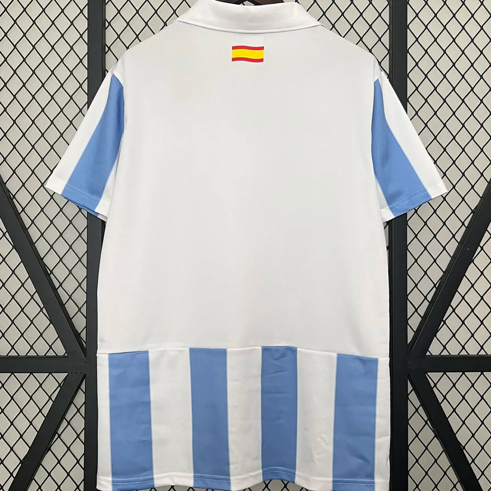 Camiseta retro Málaga CF 2012/13 primera equipación detalle escudo UCL – Cortita y al Pie