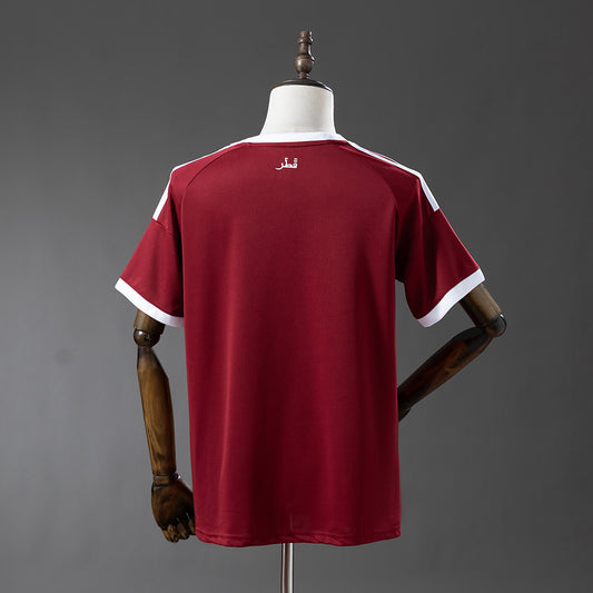 Camiseta Qatar Mundial 2026 primera equipación versión fan detalle escudo – Cortita y al Pie
